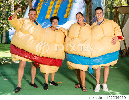 Group photo of smiling men and women wearing funny sumo suits Group photo of smiling men and women wearing funny sumo suits 122556050