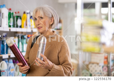 Mature woman choosing hair spray in department store Mature woman choosing hair spray in department store 122556170