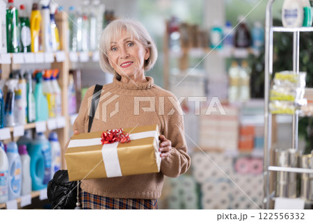 Elderly European woman with gift box in store Elderly European woman with gift box in store 122556332