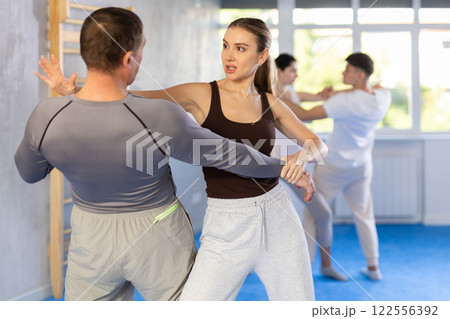 Young woman and adult man training self-defense techniques 122556392