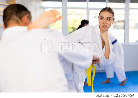 Young girl in kimono applying kicks on her partner 122556454