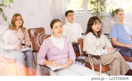 Young female student listening to lecture with focus Young female student listening to lecture with focus 122556604