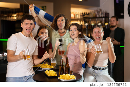 Group of friends cheer together for their favorite Greek team in beer bar 122556721