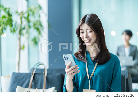 ロビーでスマホを操作するビジネスウーマン。 122558326