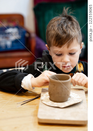 A boy creates a pot and decorating in a pottery workshop 122559065