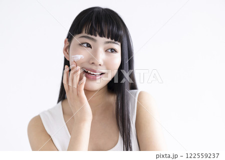 ビューティー　顔にクリームを塗っている若い女性 122559237