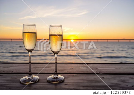 海の夕日を背景にしたシャンパングラス 122559378