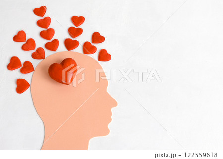 A human head filled with hearts on a light background. The concept of a man in love. A human head filled with hearts on a light background. The concept of a man in love. 122559618