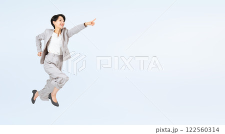 指さしてジャンプするミドル女性ビジネスパーソン 指さしてジャンプするミドル女性ビジネスパーソン 122560314