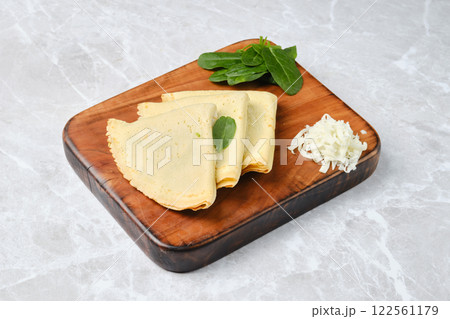 Homemade crepes with spinach and cheese on a wooden board Homemade crepes with spinach and cheese on a wooden board 122561179
