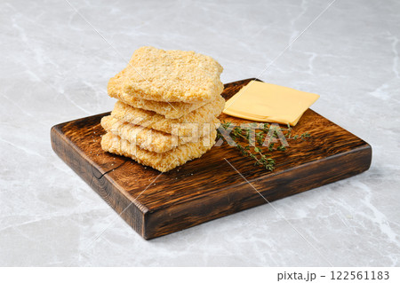 Delicious homemade cheese crackers paired with cheese and fresh herbs on a wooden board 122561183