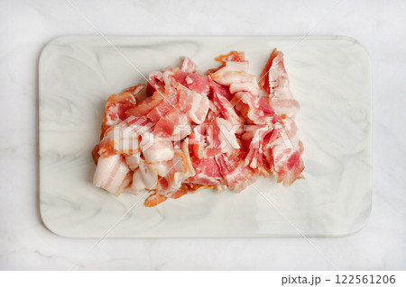 Freshly chopped pork bacon on a marble cutting board ready for cooking 122561206