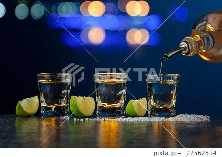 Tequila with lime and salt on a stone table. Tequila with lime and salt on a stone table. 122562314