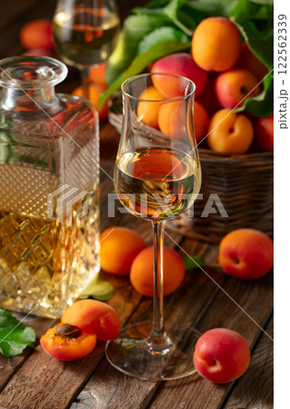 Apricot liqueur or grappa and fresh apricots. 122562339