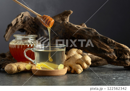 Ginger tea with honey and old snags on a black background. Ginger tea with honey and old snags on a black background. 122562342