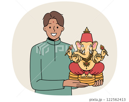 Indian man holds figurine Lord ganesha and smiles demonstrating amulet that brings good luck Indian man holds figurine Lord ganesha and smiles demonstrating amulet that brings good luck 122562413