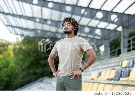 Athlete resting at the stadium, man breathing with eyes closed after active physical exercise and fitness. 122562529