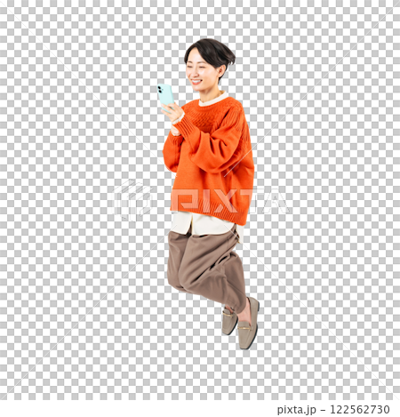 A stylish middle-aged woman jumping while looking at her smartphone. A transparent full-body photo PNG precisely cut by hand 122562730