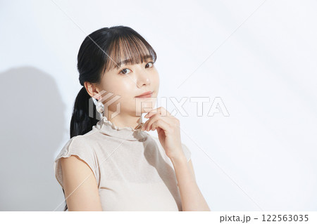 光と影の背景で撮影をした若い女性の爽やかなビューティーポートレート 122563035