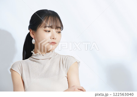 光と影の背景で撮影をした若い女性の爽やかなビューティーポートレート 122563040