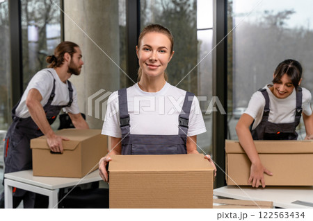 Smiling female packaging center worker with a parcel in hands Smiling female packaging center worker with a parcel in hands 122563434