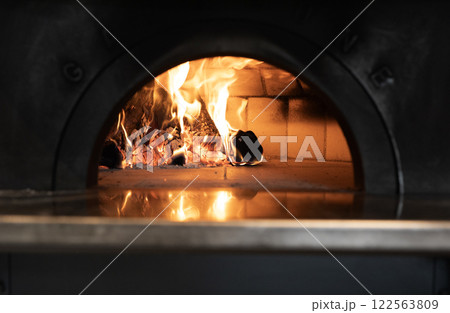 ピザ窯で燃える薪と立ち上る炎 122563809