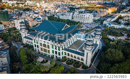 Aerial view of a large building in the city surrounded by trees 122563983