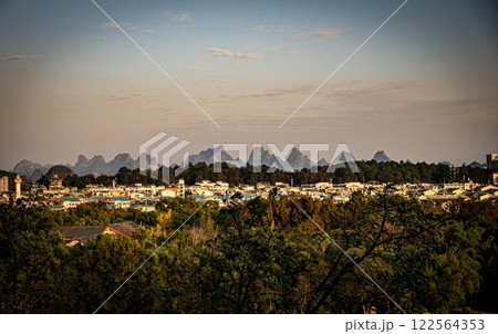Karst mountains in Guanxi, China: A city is nestled near the mountains. China. Karst mountains in Guanxi, China: A city is nestled near the mountains. China. 122564353