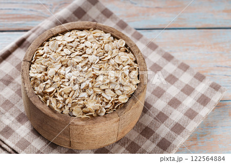 Raw Rolled Oats in Wooden Bowl, Healthy Eating Concept, Copy Space Raw Rolled Oats in Wooden Bowl, Healthy Eating Concept, Copy Space 122564884