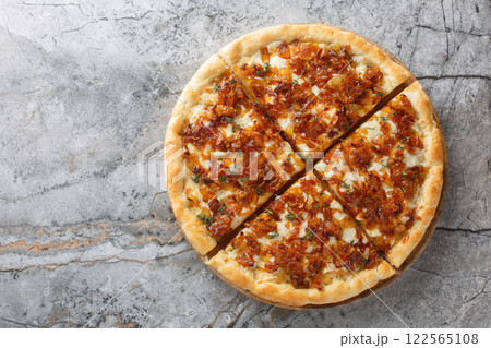 Homemade delicious French onion pizza with gruyere and mozzarella cheese, thyme and garlic close-up on a wooden board. Horizontal top view Homemade delicious French onion pizza with gruyere and mozzarella cheese, thyme and garlic close-up on a wooden board. Horizontal top view 122565108
