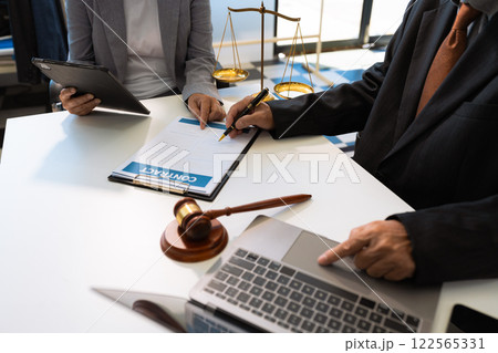 Business people and lawyers discussing contract papers sitting in the table at office in the morning. concepts of law, advice, legal services. Business people and lawyers discussing contract papers sitting in the table at office in the morning. concepts of law, advice, legal services. 122565331