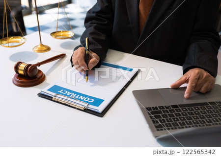Serious pensive lawyer working at desk in office. Serious pensive lawyer working at desk in office. 122565342