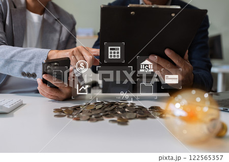 businessman hand holding lightbulb with saving money in office. businessman hand holding lightbulb with saving money in office. 122565357