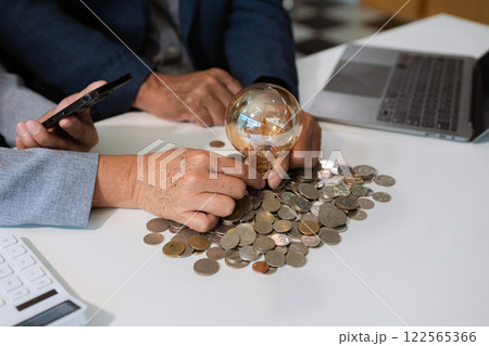 businessman hand holding lightbulb with using laptop computer and money stack in office. idea saving energy and accounting finance concept in office. businessman hand holding lightbulb with using laptop computer and money stack in office. idea saving energy and accounting finance concept in office. 122565366