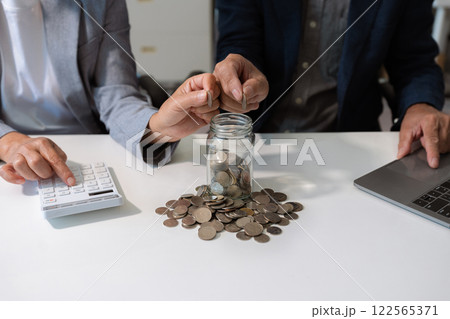 concept with saving money, accountant working on desk in home using calculator and laptop to calculate budget. concept with saving money, accountant working on desk in home using calculator and laptop to calculate budget. 122565371