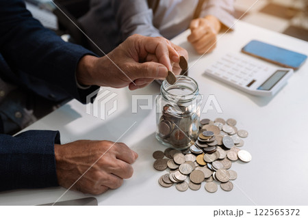 concept with saving money, accountant working on desk in home using calculator and laptop to calculate budget. concept with saving money, accountant working on desk in home using calculator and laptop to calculate budget. 122565372