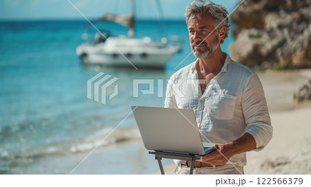 海を眺めながらラップトップで働くエレガントなシニア男性 122566379