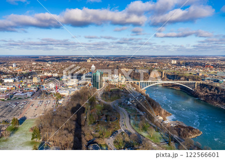 Niagara Falls City, Ontario, Canada - December 19 2021 : Overlooking the Niagara River Rainbow Bridge in a sunny day. 122566601
