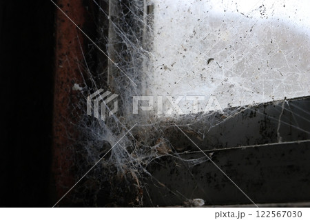 廃墟の工場の窓に張られた蜘蛛の巣 廃墟の工場の窓に張られた蜘蛛の巣 122567030