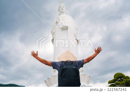 back of a male tourist traveler at Lady Buddha statue at Linh Ung Pagoda in Da Nang in Vietnam. Concept of travel and tourism in Asia 122567241