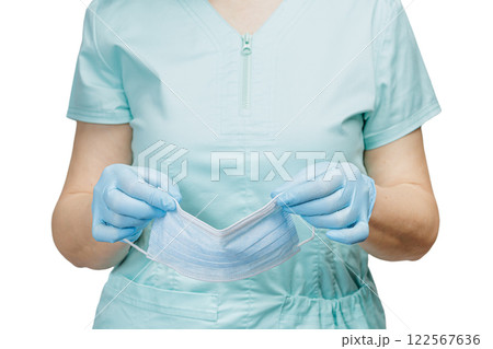 Hands of a female doctor in latex gloves with a medical mask. 122567636