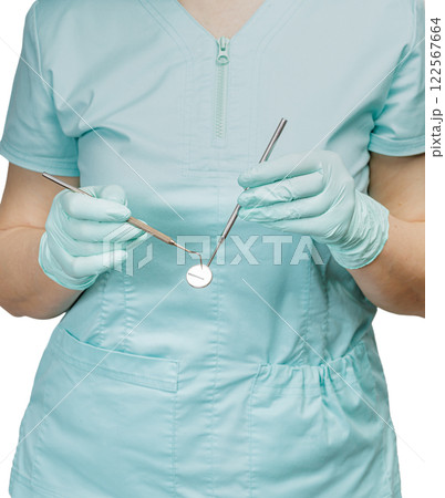 Dentist's hands with a probe and a mouth mirror. Dentist's hands with a probe and a mouth mirror. 122567664