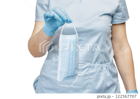 Hand of a female doctor in a latex glove with a medical mask. 122567707