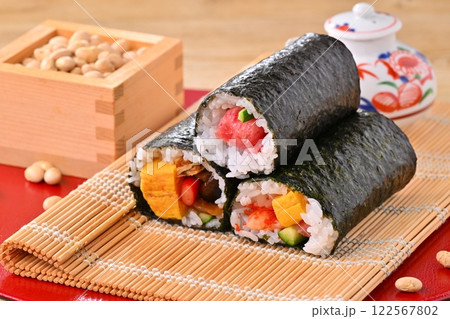 節分の恵方巻と福豆のイメージ。縁起物、厄除け、二月の行事。 節分の恵方巻と福豆のイメージ。縁起物、厄除け、二月の行事。 122567802