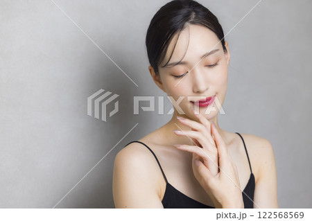 頬に手を当てる若い女性  122568569