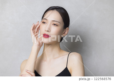 頬に手を当てる若い女性  122568576