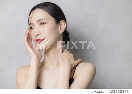 頬に手を当てる若い女性  122568578