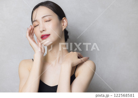 頬に手を当てる若い女性  122568581