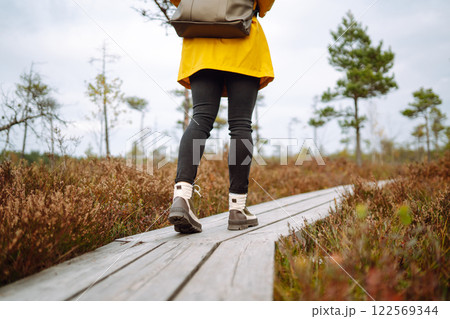 Hiking shoes of woman walking on wooden bridge. Copy Space on outdoor background. Active lifestyle Hiking shoes of woman walking on wooden bridge. Copy Space on outdoor background. Active lifestyle 122569344