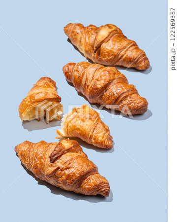 Fresh croissants on blue background with shadow. Creative layout for cafe advertising concept. 122569387